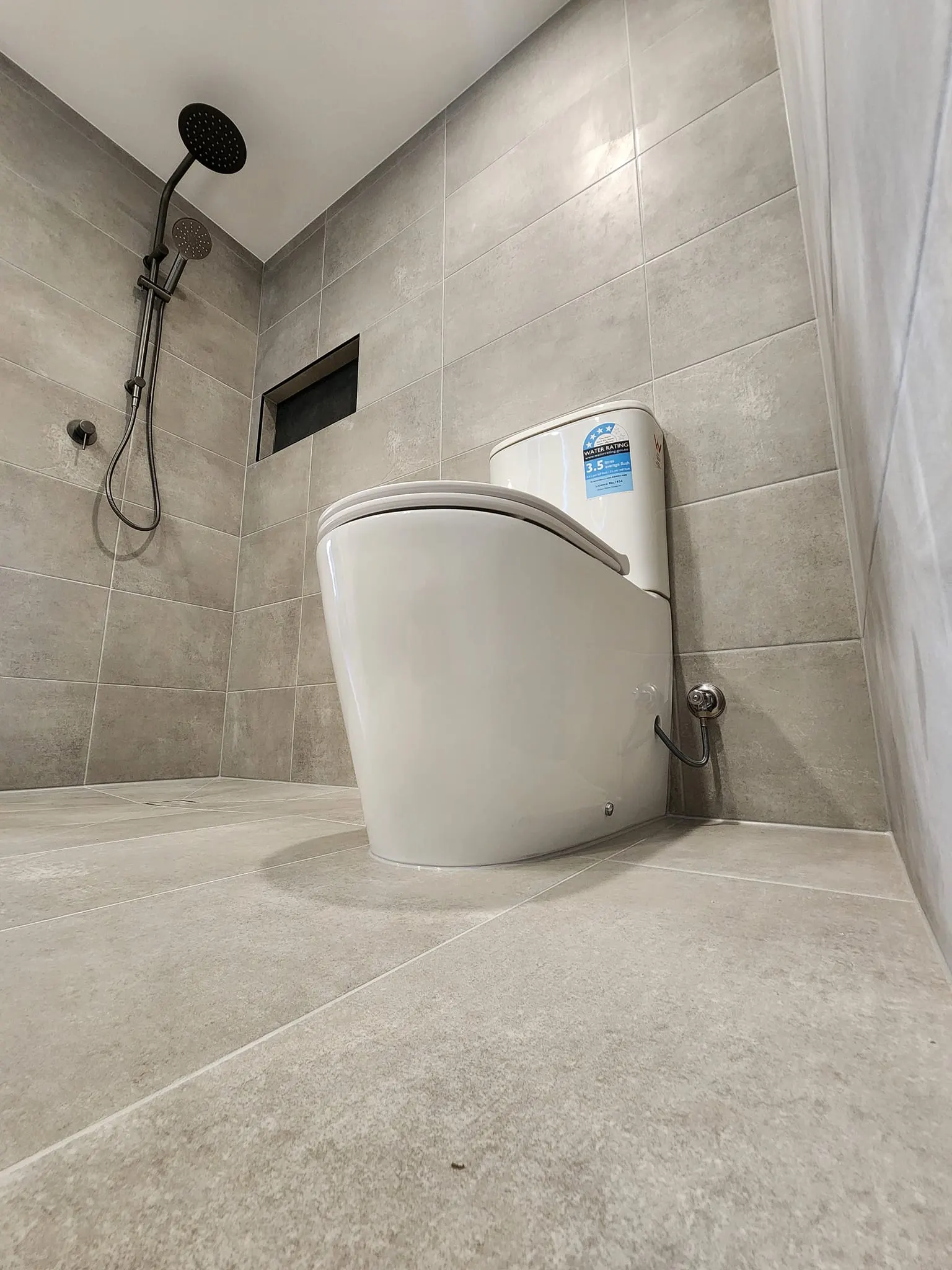In-wall cistern and pan installed in a tiled bathroom